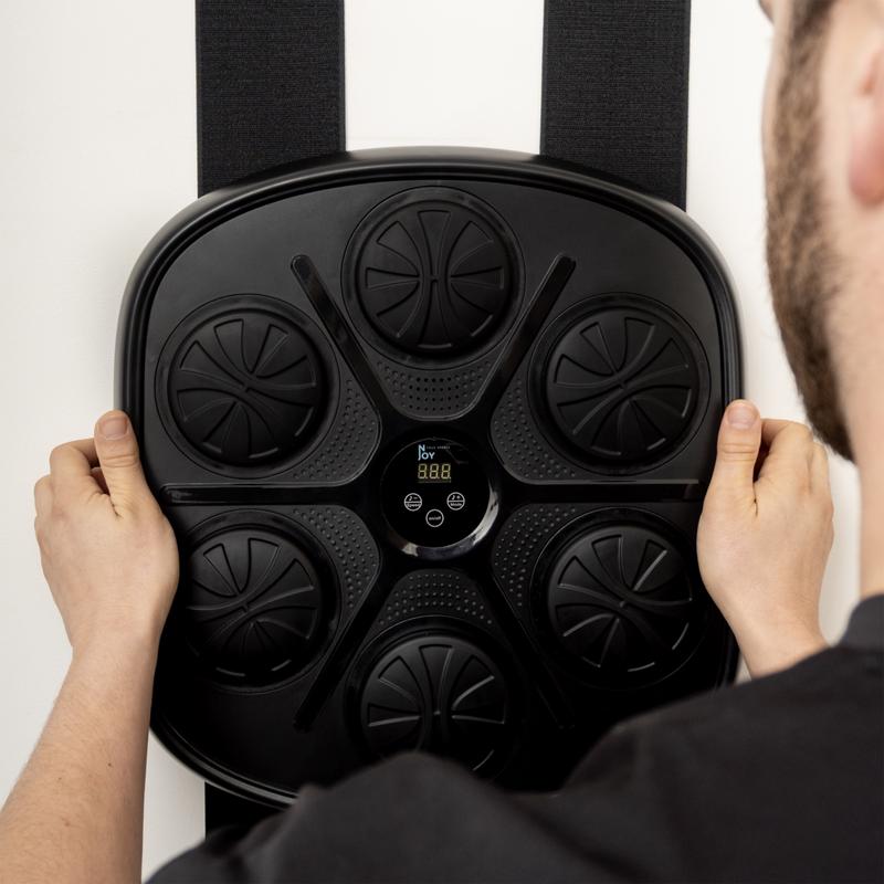 Iemand hangt de Action boksmachine met twee banden aan de muur